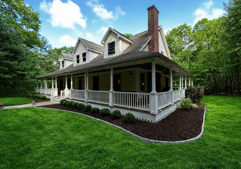 Classic New England farmhouse with wraparound porch in Rhode Island
